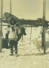 George Ahgupuk standing by an Alaskan cache